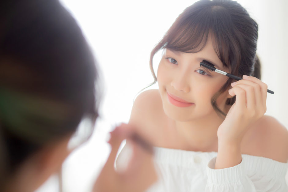 Beautiful young asian woman applying makeup eyebrows brush, beau